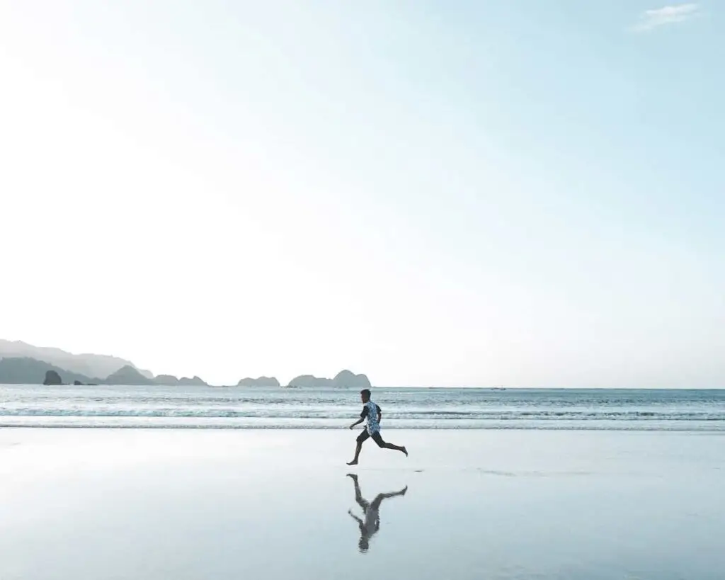 Runner on the beach with blue skies on a clear day