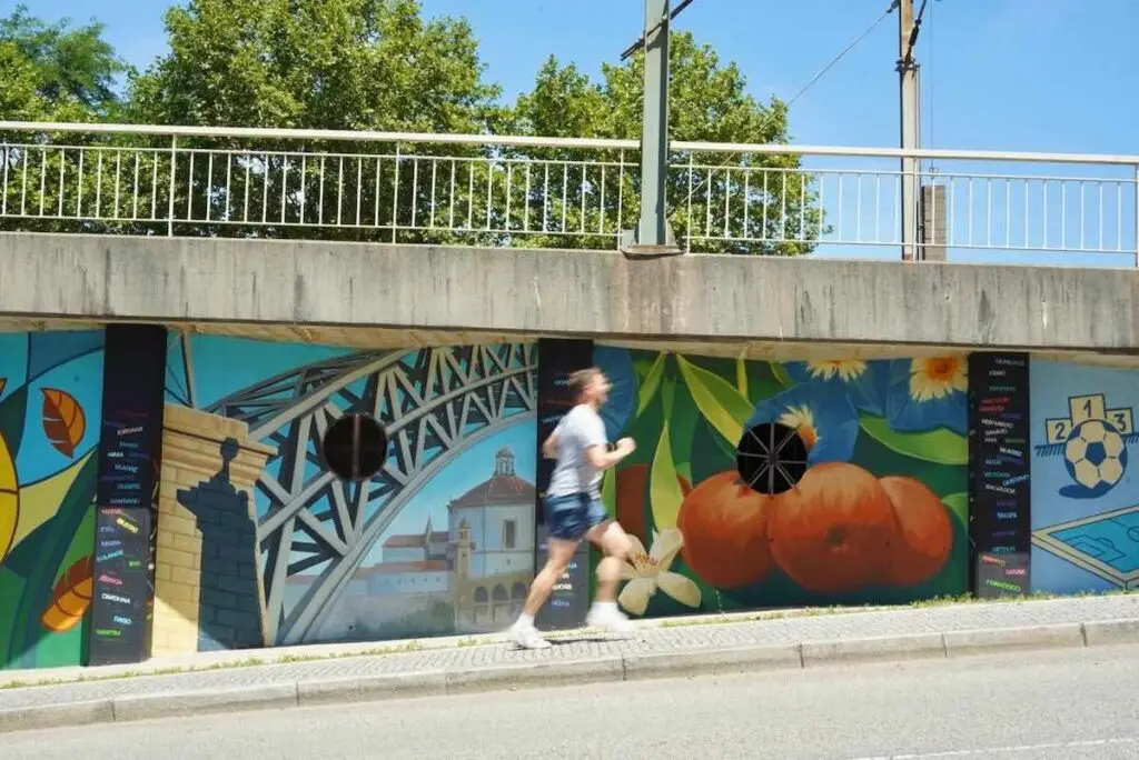 Runner running up hill against a graffiti wall