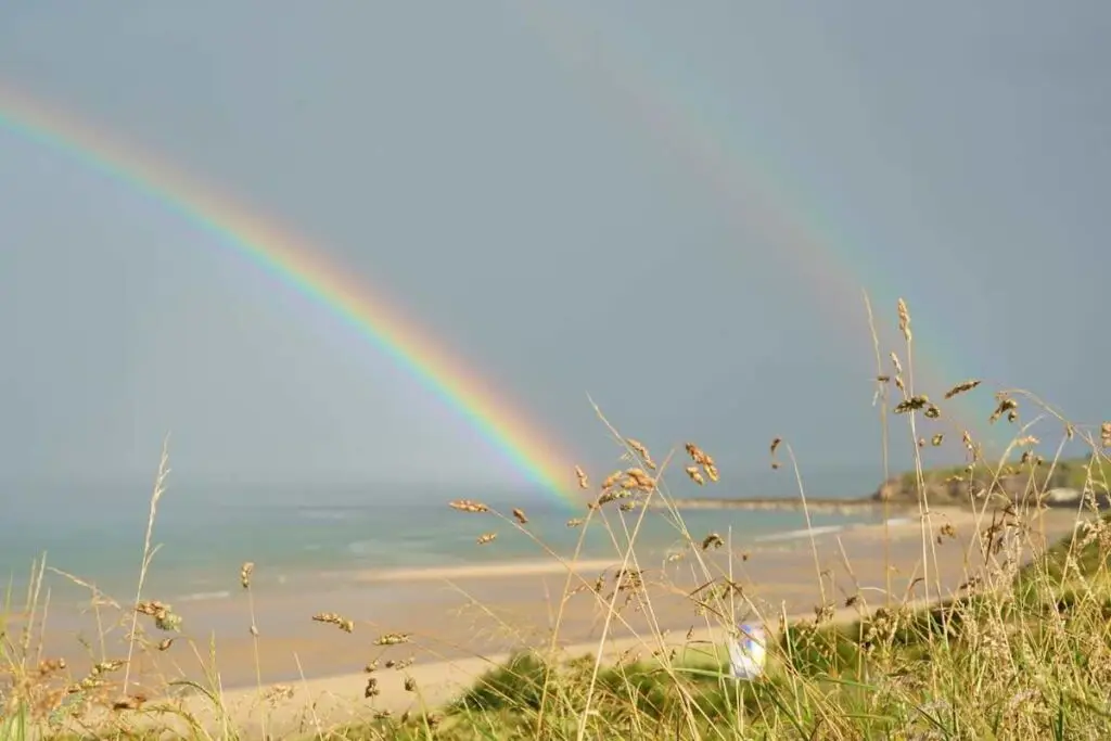 Double rainbow caught running by the sea