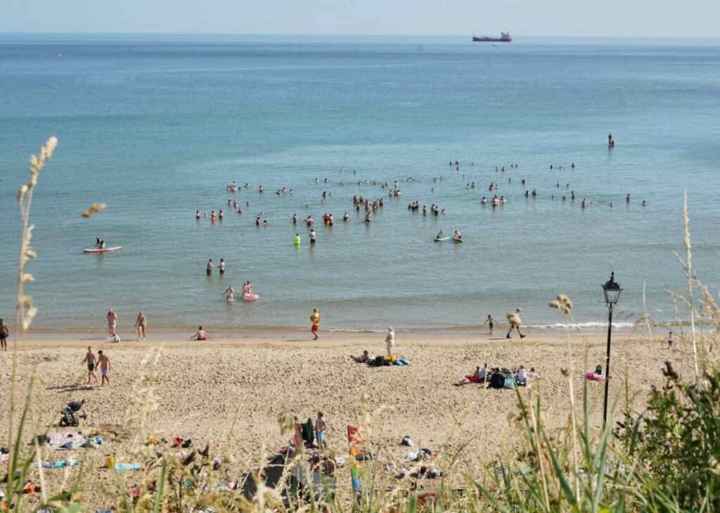 Holidaymakers swimming in the sea and enjoying the beach