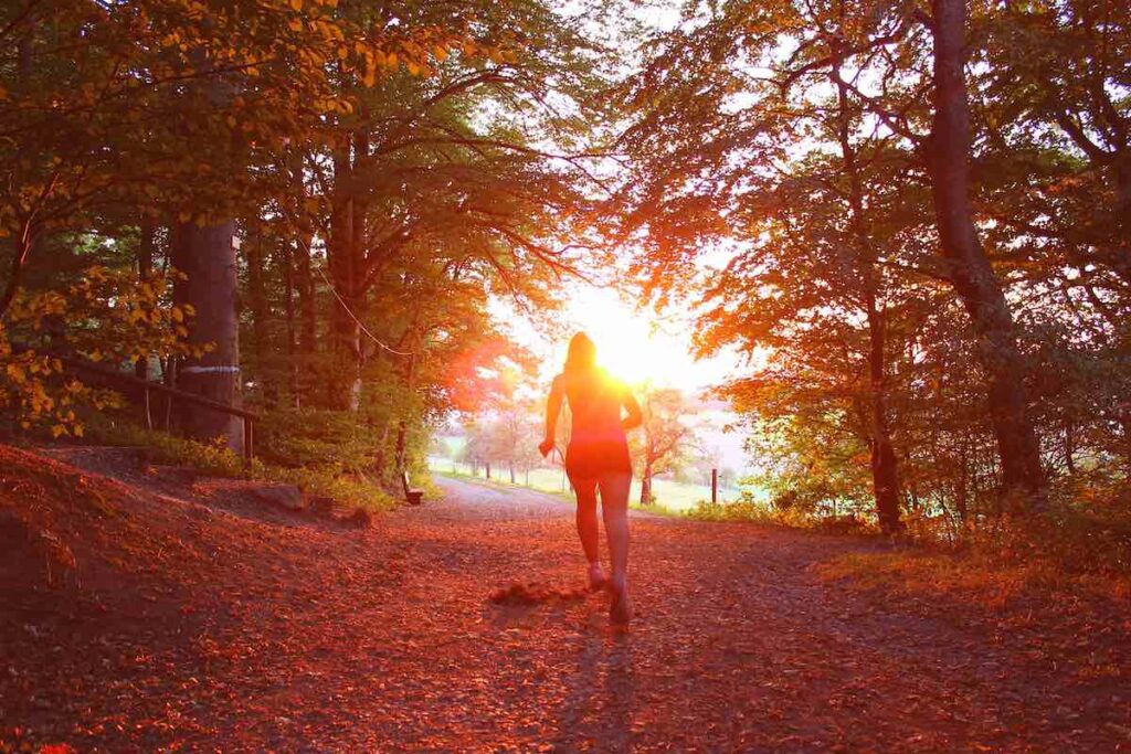 Lady running through a forest in fall