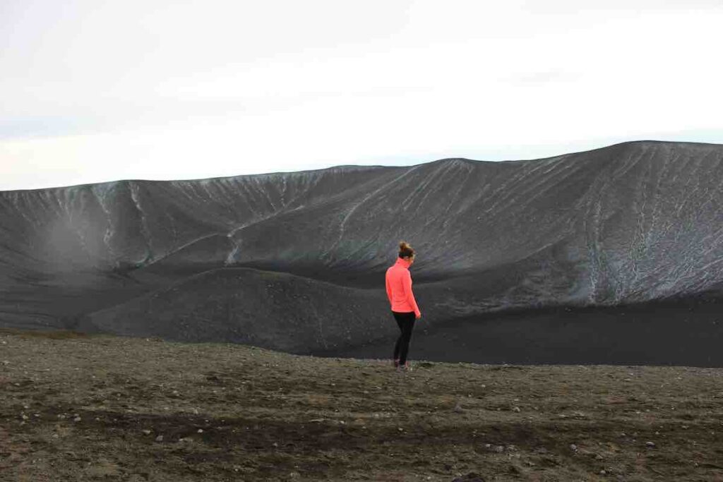 Lone runner on a grey volcanic landscape