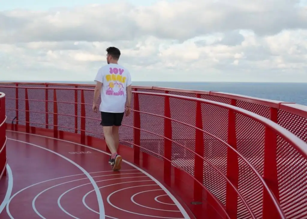 Runner on red Virgin Voyages running track