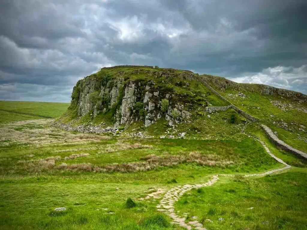 A view of Hadrian’s wall in Northumberland as it runs up a craggy hillside of a Roman fortification